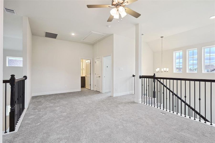 Empty room with a chandelier and light colored carpet