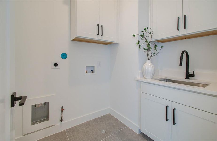 Walk-in laundry with cabinets and a wash sink