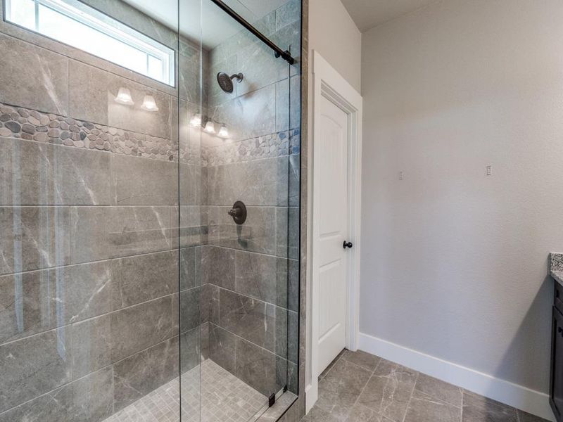 Full bath with vanity, baseboards, and a shower stall