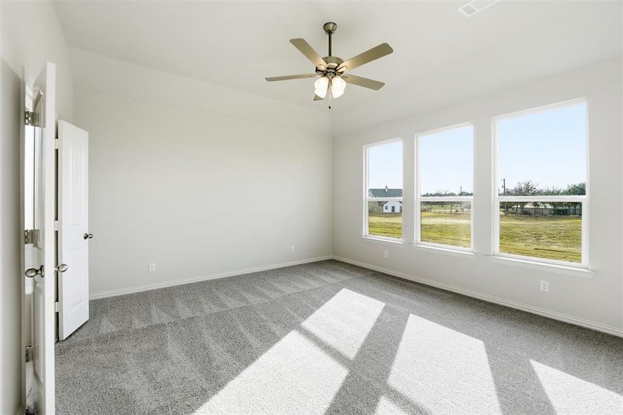 Unfurnished room with carpet floors and a ceiling fan