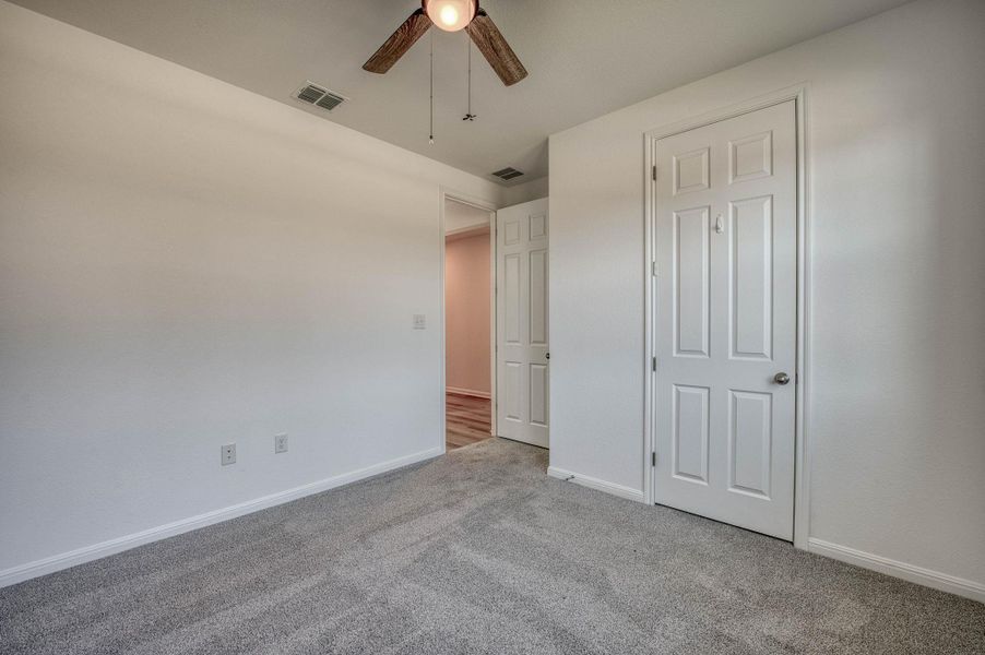 Plush carpeting anchors this versatile room boasting crisp baseboards and clean architectural lines.