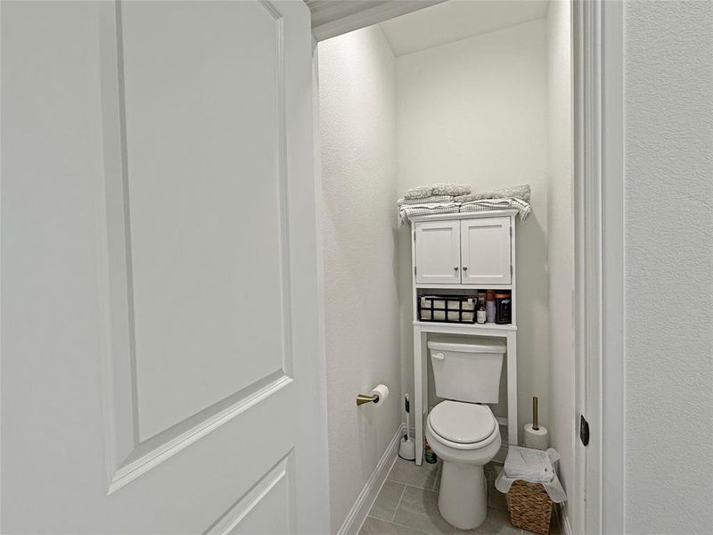 Bathroom featuring toilet and light tile patterned floors Bathroom featuring toilet and light tile patterned floors