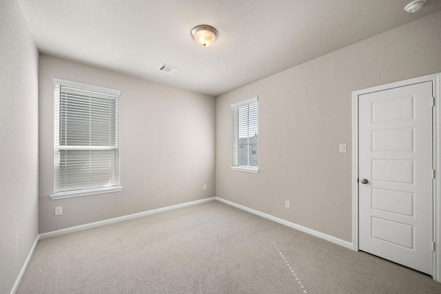 The spacious second bedroom offers ample room for a queen-sized bed, creating a comfortable retreat for family or guests.