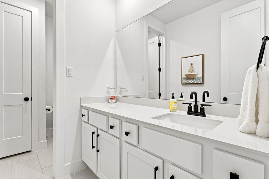 A spacious vanity with contemporary black fixtures provides abundant storage and clean lines.