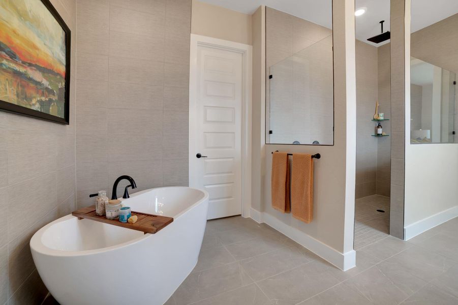 Bathroom with tile walls, a freestanding tub, a walk in shower, and light tile patterned floors