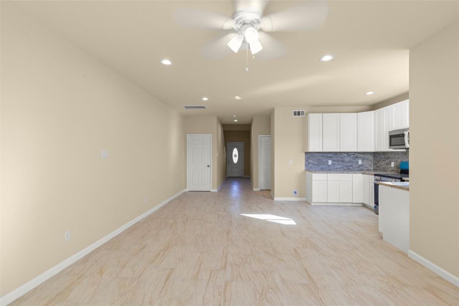 This modern kitchen features sleek white cabinets, a stylish gray tile backsplash, and stainless steel appliances, including a stove, microwave, and dishwasher. The space is well-lit with recessed lighting and has a window above the sink, providing natural light. This modern kitchen features sleek white cabinets, a stylish gray tile backsplash, and stainless steel appliances, including a stove, microwave, and dishwasher. The space is well-lit with recessed lighting and has a window above the sink, providing natural light.