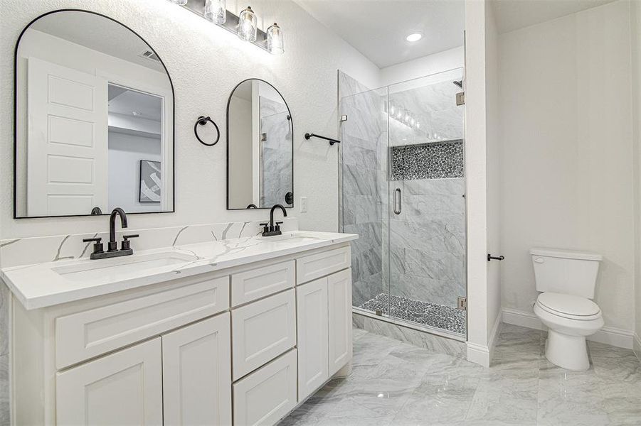 Bathroom featuring vanity, toilet, and an enclosed shower