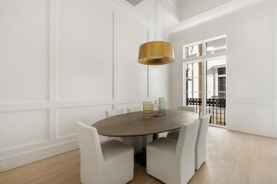 The dining area benefits from abundant natural light. The custom-stained hardwoods gleam under the filtered sunlight in this lovely space. (photo of interior model home with smaller floor plan)