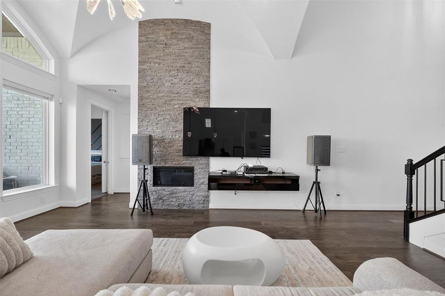 Living area featuring dark wood-type flooring, stairway, and high vaulted ceiling Living area featuring dark wood-type flooring, stairway, and high vaulted ceiling