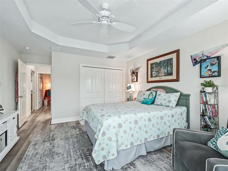 Front bedroom with coffered ceiling, bay windows, and plantation shutters