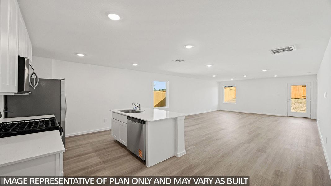 Kitchen with white cabinets, light wood-type flooring, a center island with sink, open floor plan, and recessed lighting