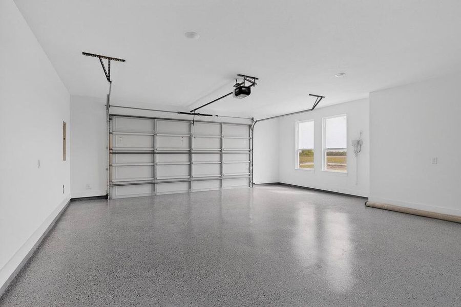 Garage featuring baseboards and a garage door opener Garage featuring baseboards and a garage door opener