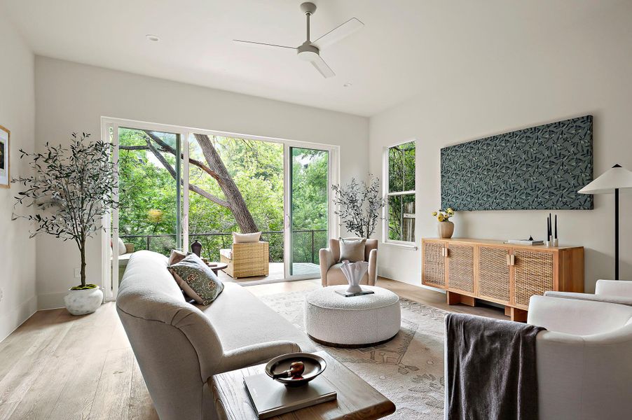 Living area with plenty of natural light, ceiling fan, and wood finished floors