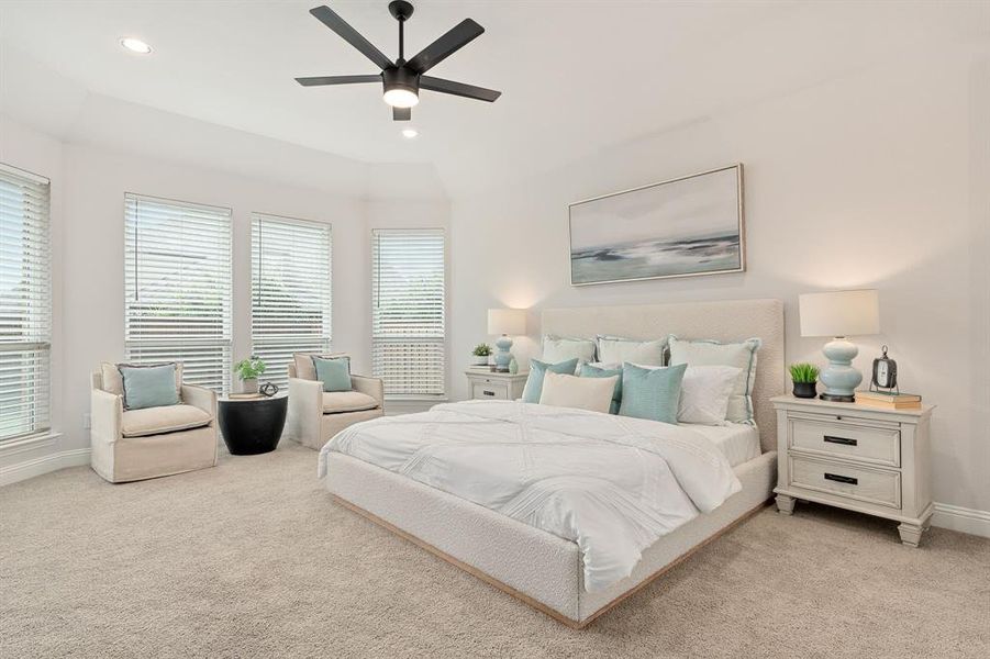 Spacious primary bedroom featuring bay windows and views of the backyard