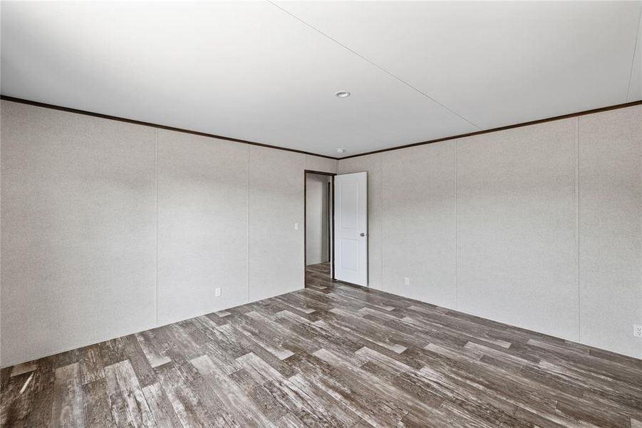 Empty room featuring hardwood / wood-style floors and ornamental molding