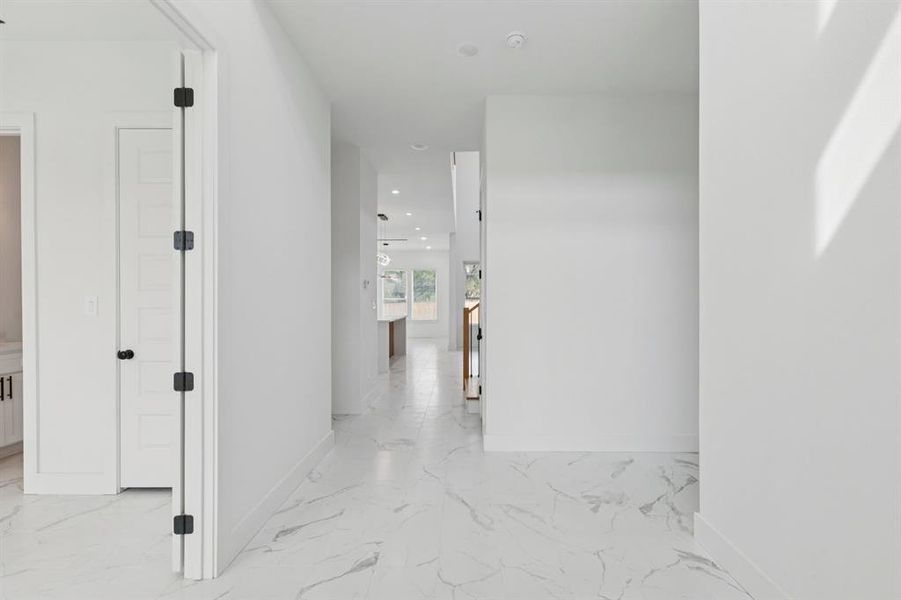 Corridor with light marble finish flooring and recessed lighting