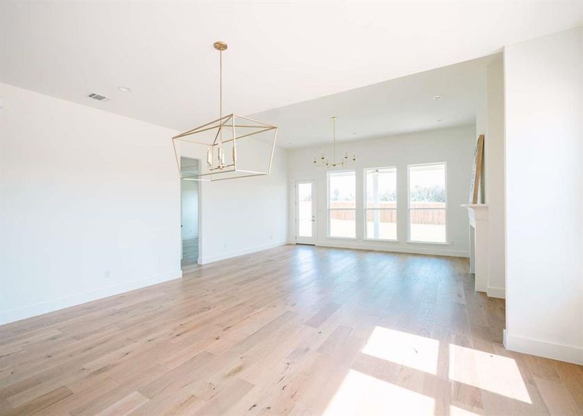 Empty room featuring a chandelier and light wood-type flooring