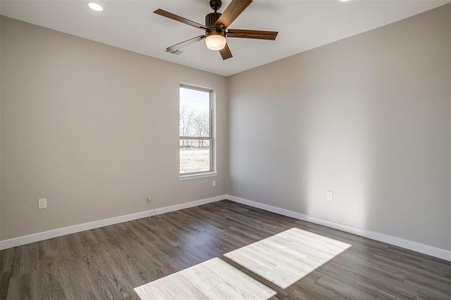 Unfurnished room featuring ceiling fan and dark wood-type flooring