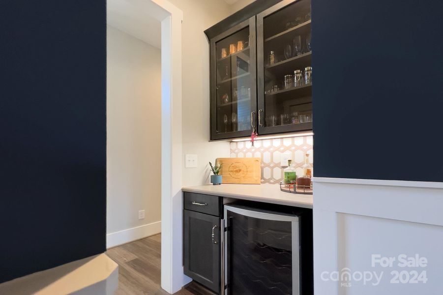 Butler's pantry with glass front cabinetry and custom backsplash