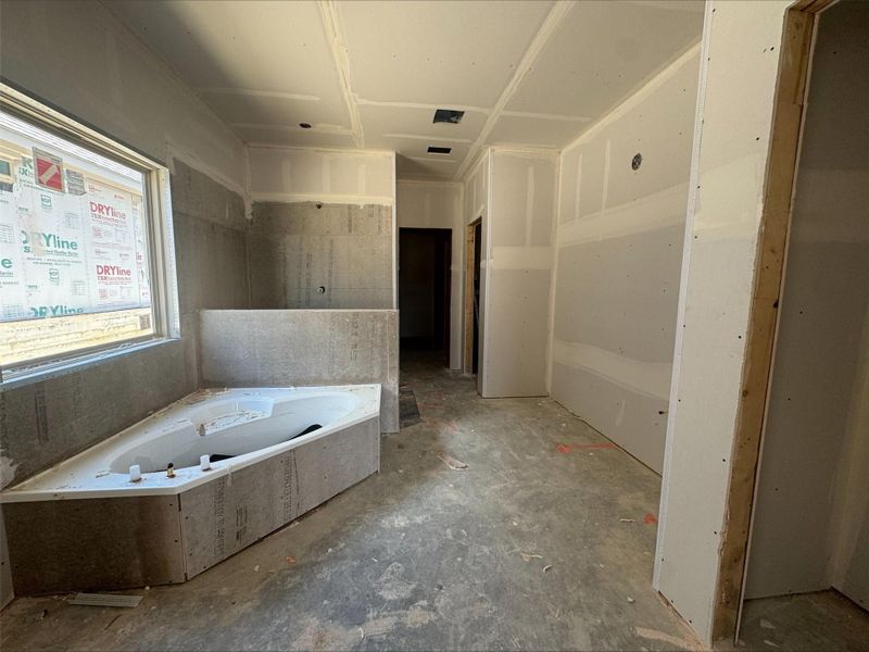 Full bath featuring a whirlpool tub and concrete floors