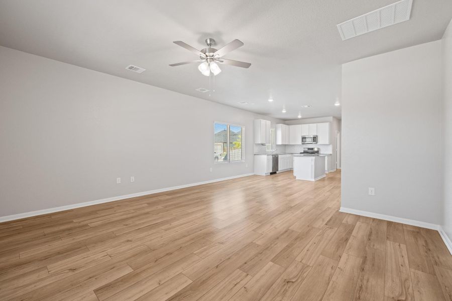 Unfurnished living room with light wood-type flooring and ceiling fan Unfurnished living room with light wood-type flooring and ceiling fan
