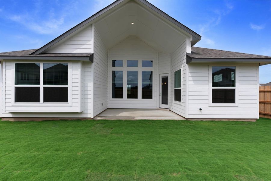 A verdant lawn extends from a freshly built structure featuring expansive windows and a covered patio. A verdant lawn extends from a freshly built structure featuring expansive windows and a covered patio.