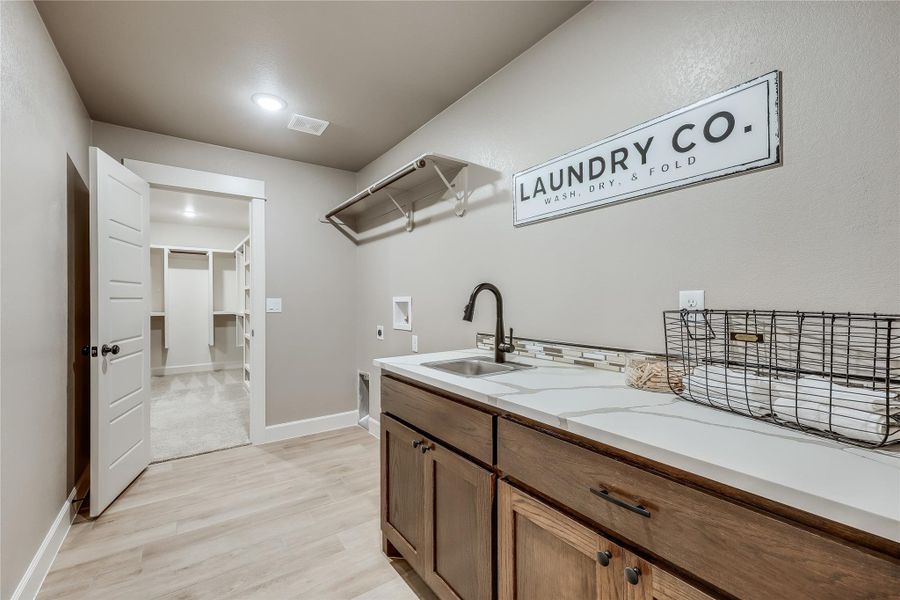 A client favorite: huge laundry room with sink located off shared hallway AND primary closet.