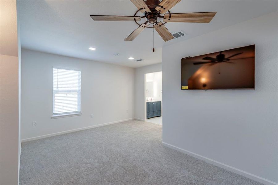 Carpeted spare room featuring ceiling fan