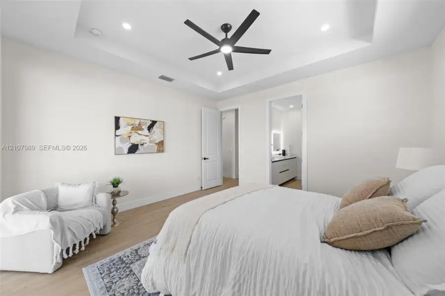 Tray ceiling with recessed lighting, integrated matte black ceiling fan, wood-finish flooring, and recessed LED ceiling lights Tray ceiling with recessed lighting, integrated matte black ceiling fan, wood-finish flooring, and recessed LED ceiling lights