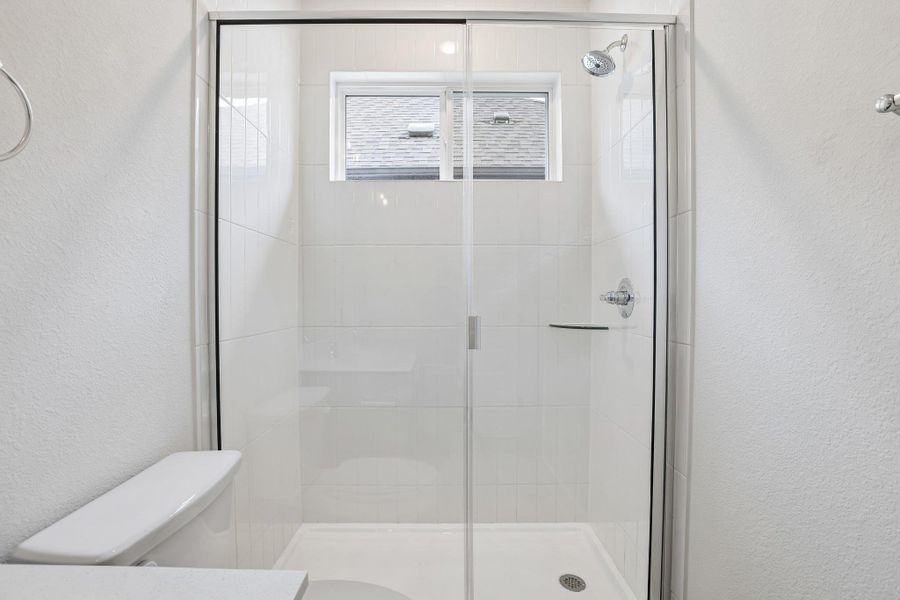 The ensuite also features an oversized shower enclosed by frameless glass.