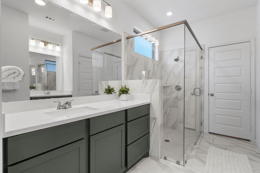 Bathroom with vanity, a marble finish shower, and light marble finish floors