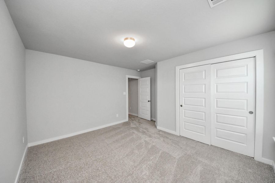 Generously sized secondary bedrooms featuring spacious closets, soft and inviting carpeting underfoot, large windows allowing plenty of natural light, and the added touch of privacy blinds for your personal retreat. Sample photo of completed home with similar floor plan. Actual colors and selections may vary.