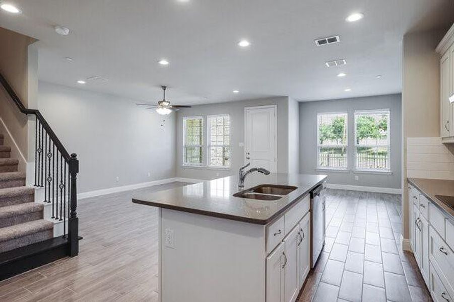 Kitchen featuring a sink, healthy amount of natural light, recessed lighting, dishwasher, and dark countertops