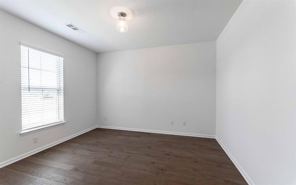 Room featuring wood-finish flooring, white walls, and white baseboards