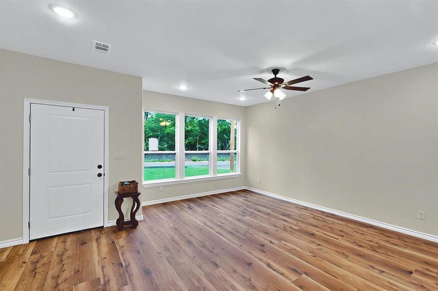 Empty room featuring ceiling fan, recessed lighting, baseboards, wood finished floors, and visible vents Empty room featuring ceiling fan, recessed lighting, baseboards, wood finished floors, and visible vents