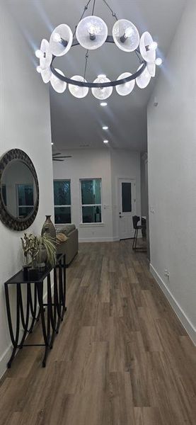 Corridor featuring dark wood finished floors and suspended lighting Corridor featuring dark wood finished floors and suspended lighting
