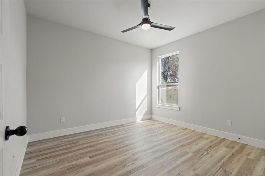 Unfurnished room with ceiling fan and light wood-type flooring