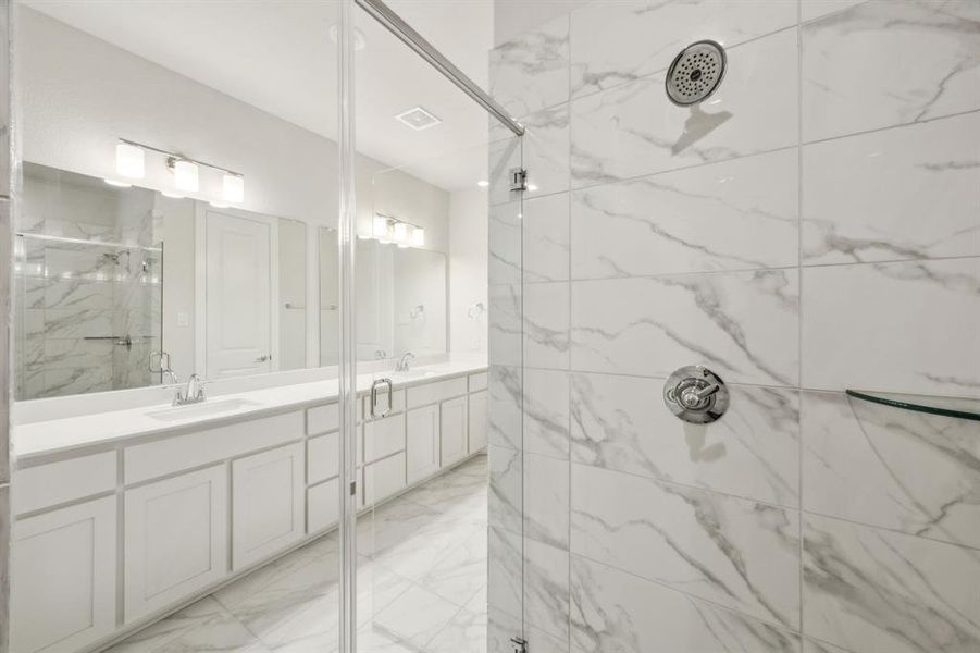 Primary Bathroom featuring dual sink vanity and a walk in shower