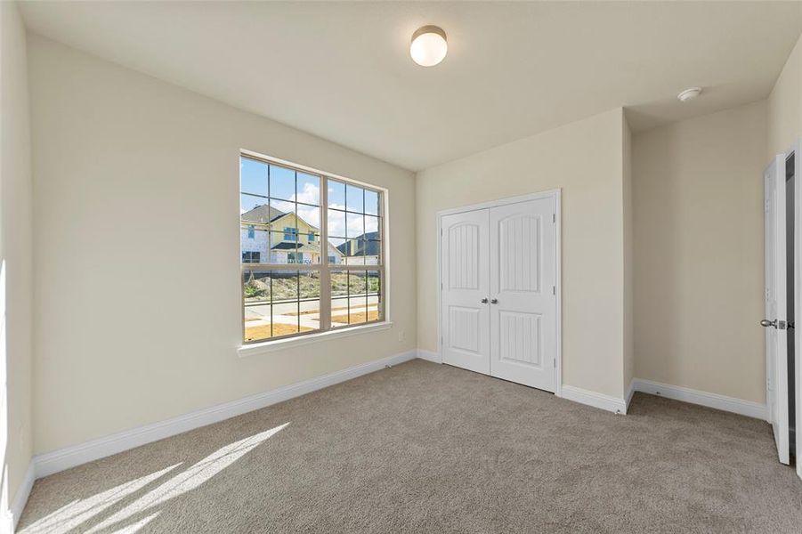 Unfurnished bedroom featuring light colored carpet and a closet