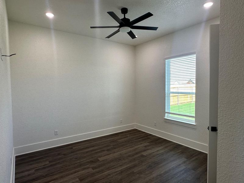 Empty room with dark wood-style floors, ceiling fan, a textured wall, recessed lighting, and a textured ceiling