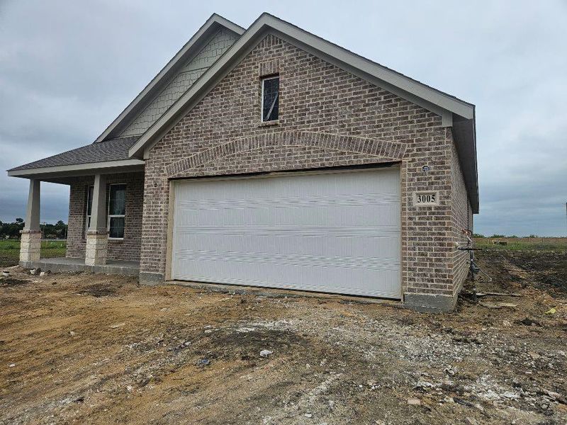 Brick exterior featuring a gabled roofline and covered front porch with stone-wrapped columns Brick exterior featuring a gabled roofline and covered front porch with stone-wrapped columns
