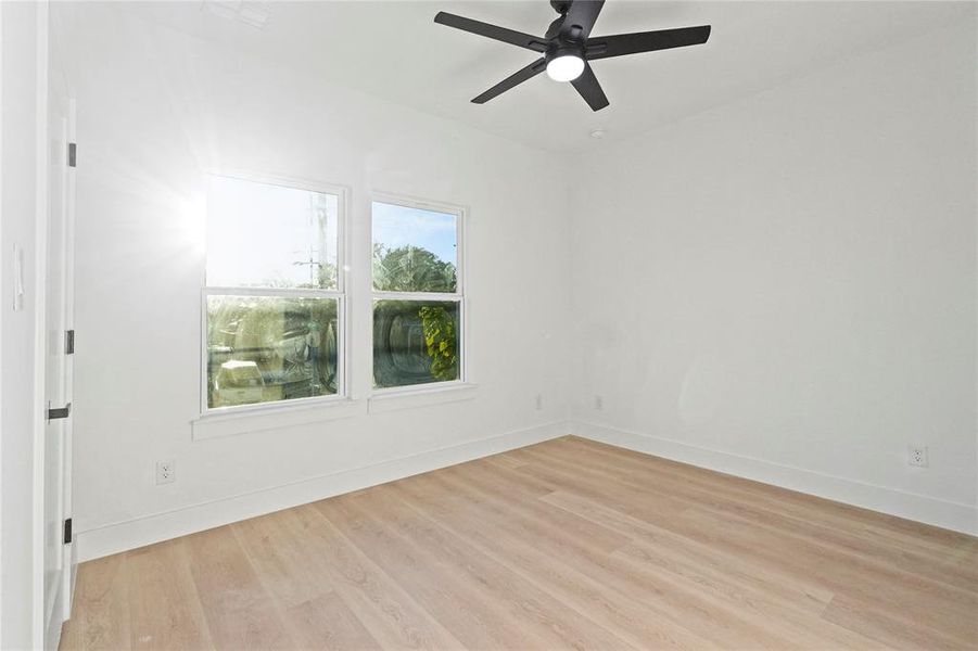 Spare room featuring light wood finished floors and a ceiling fan Spare room featuring light wood finished floors and a ceiling fan