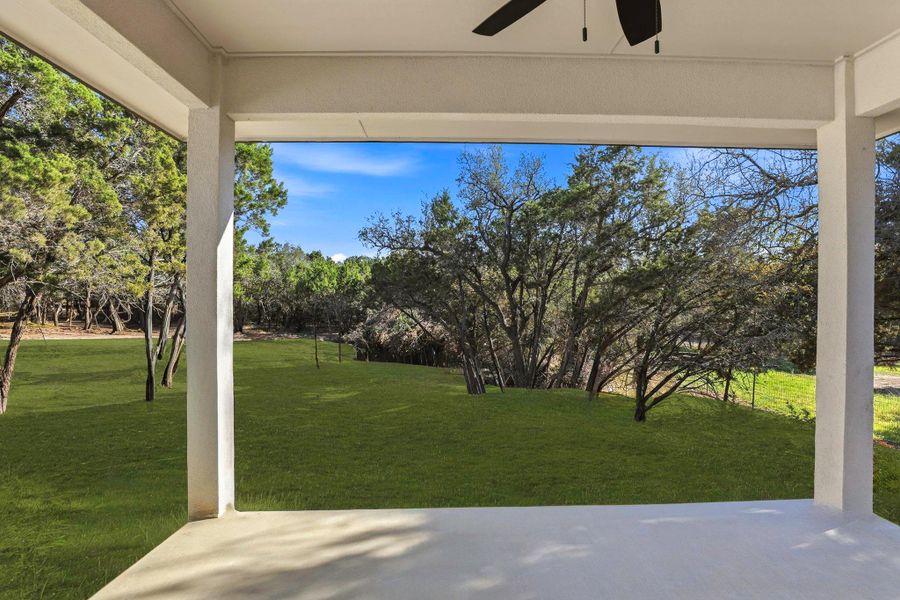 A spacious covered patio invites peaceful outdoor living overlooking a verdant lawn and mature trees. A spacious covered patio invites peaceful outdoor living overlooking a verdant lawn and mature trees.