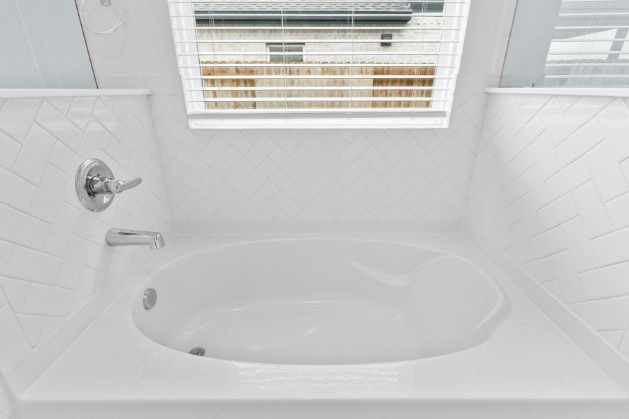 Deep soaking tub surrounded by tile accents and natural light from the window — call now to make this luxurious escape yours! Deep soaking tub surrounded by tile accents and natural light from the window — call now to make this luxurious escape yours!