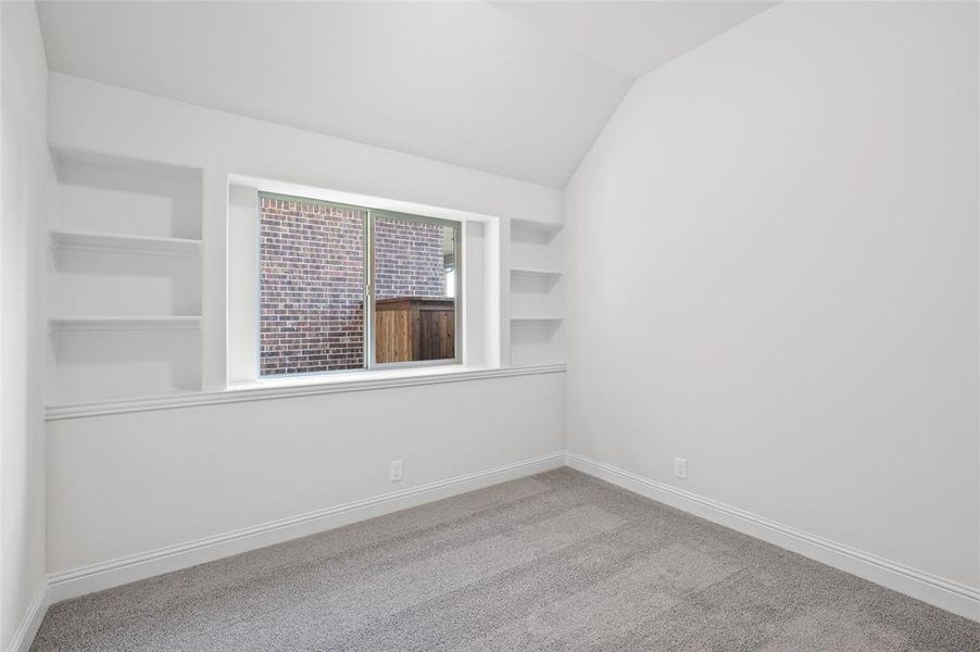 Unfurnished room with light carpet and lofted ceiling