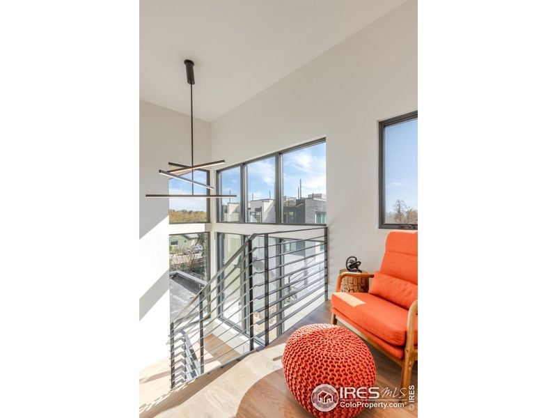 An intimate sitting area at the top of the staircase allows for a quiet reading/sitting nook.