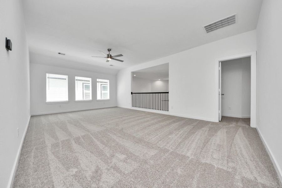 Ascend to relaxation in this fantastic game room! Ideal for both casual gatherings and adult gaming, it boasts plush carpet, lofty ceilings, custom paint, and ample windows for abundant natural light. Sample photo of completed home with similar floor plan. Actual colors and selections may vary.