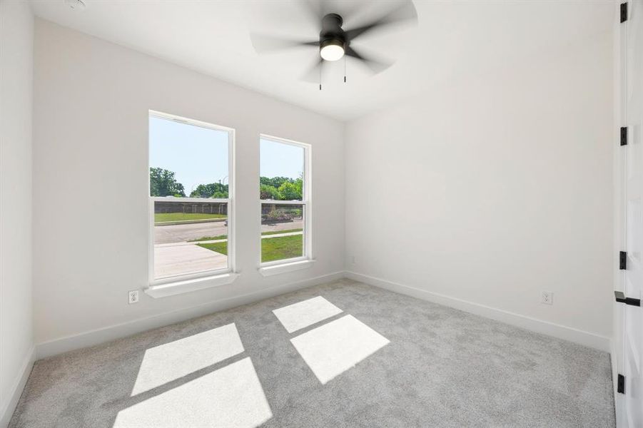 Room featuring light gray carpeting, crisp white walls, and a contemporary ceiling fan with integrated lighting Room featuring light gray carpeting, crisp white walls, and a contemporary ceiling fan with integrated lighting