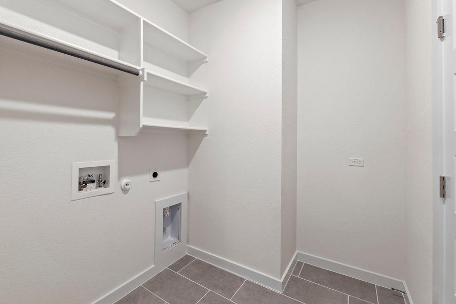 Functional laundry room offers ample storage with built-in shelving and convenient hookups. Functional laundry room offers ample storage with built-in shelving and convenient hookups.