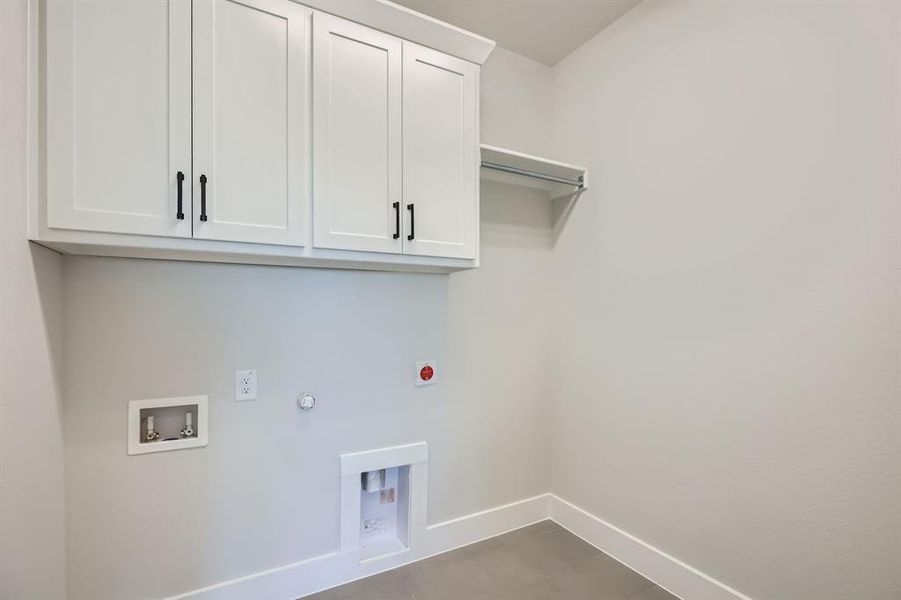 Laundry room with hookup for an electric dryer, cabinet space, baseboards, gas dryer hookup, and washer hookup Laundry room with hookup for an electric dryer, cabinet space, baseboards, gas dryer hookup, and washer hookup